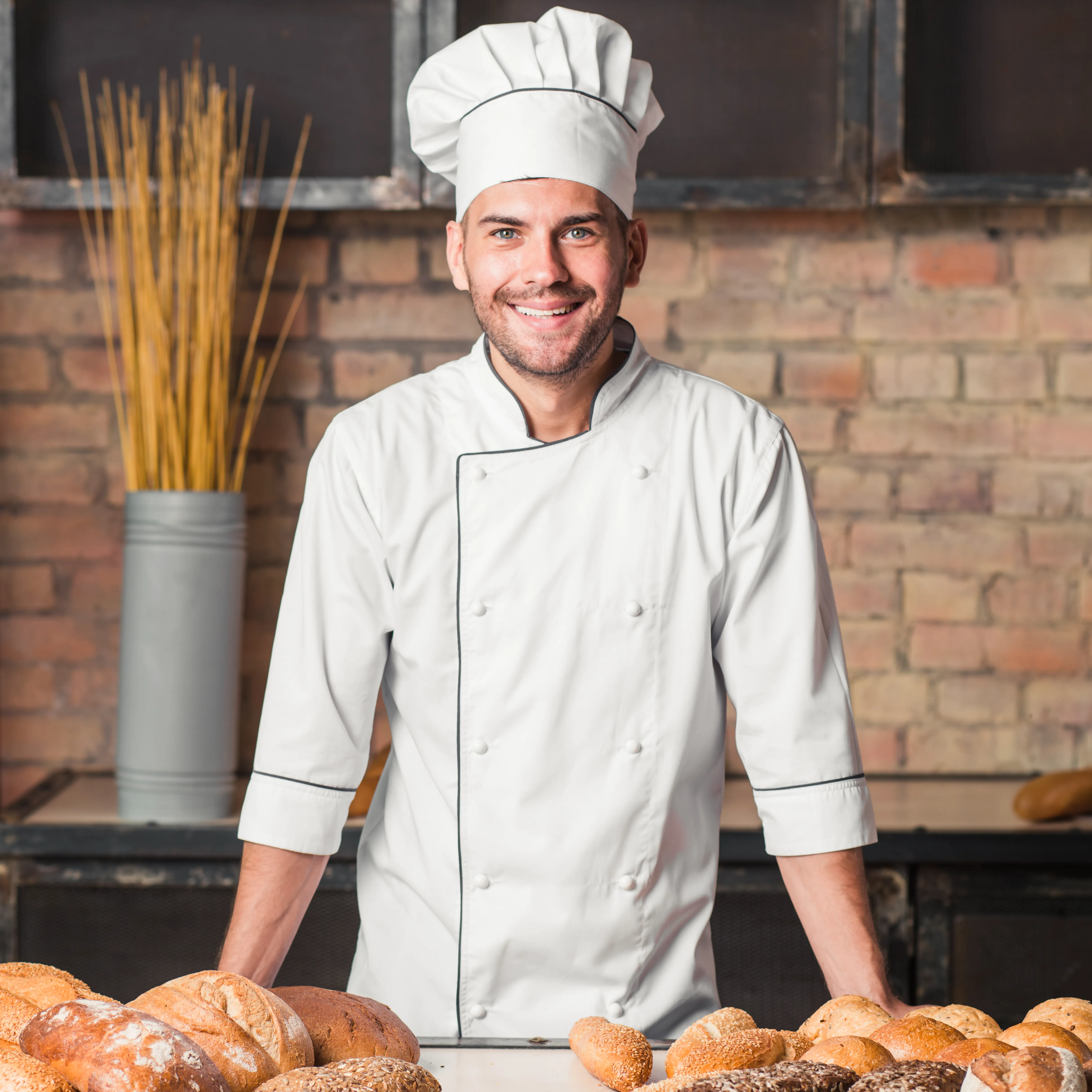 Smiling baker with a table of freshly baked breads